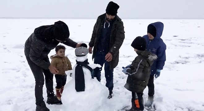 Donmuş göl üzerinde kardan adam yapıp, kar topu oynadılar